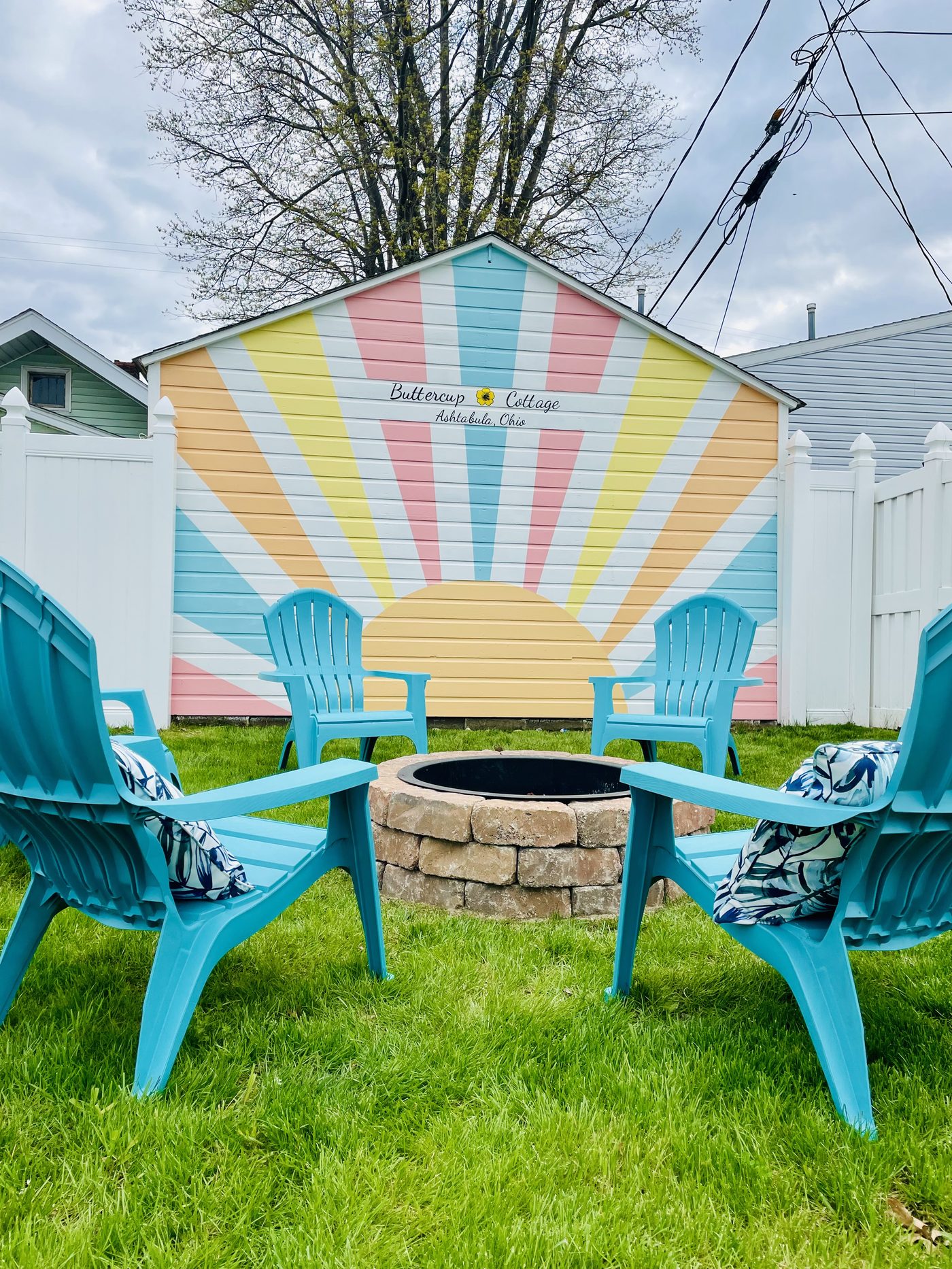 Fenced backyard with fire pit and chairs